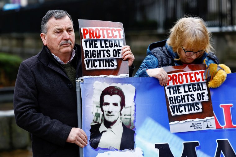 John Teggart holds a sign and a banner.