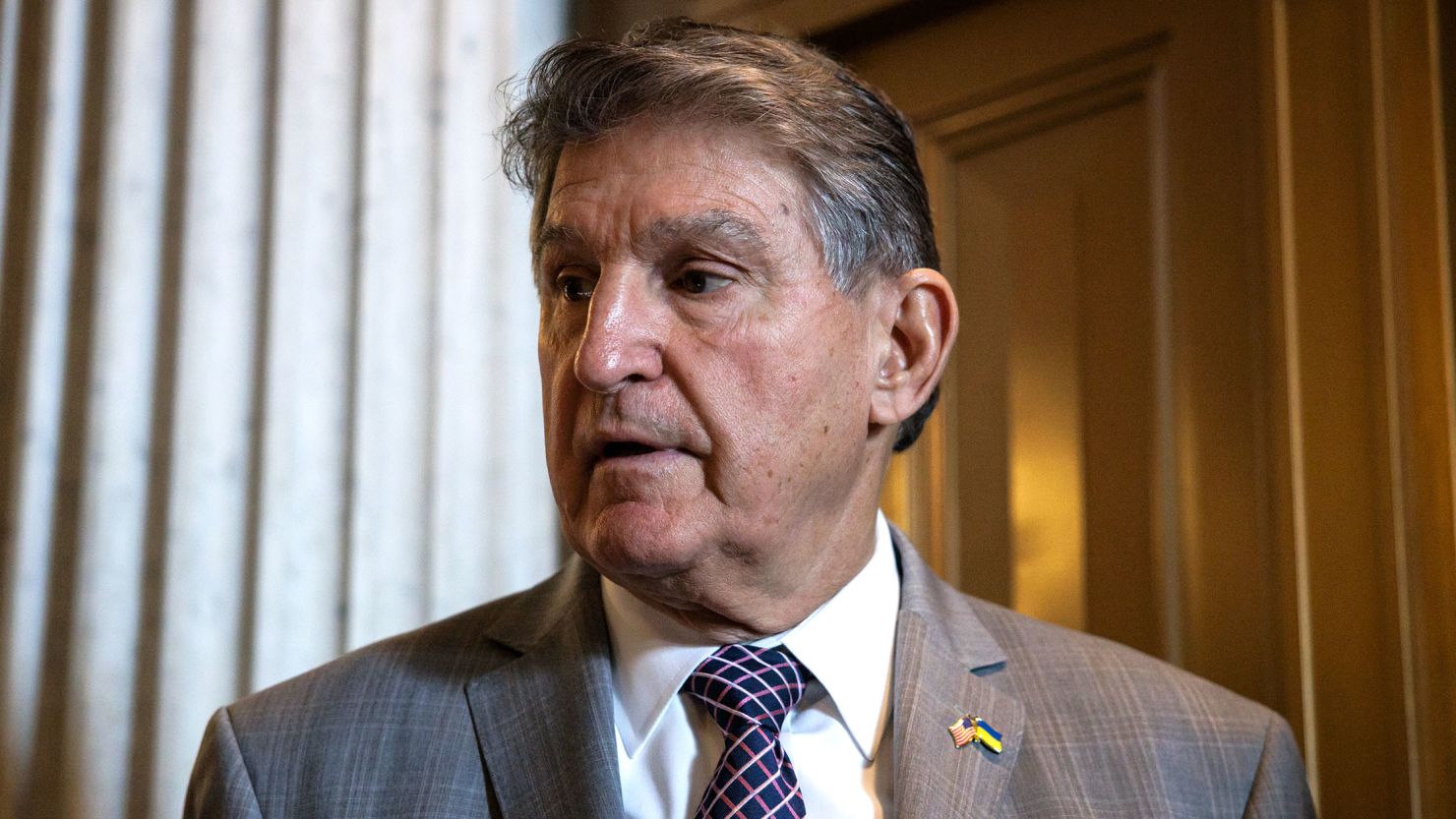 Sen. Joe Manchin talks to reporters as he leaves the Senate floor following a vote on January 23 in Washington, DC.