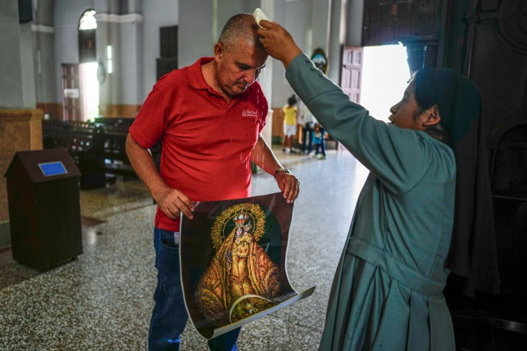 Ramon Nieblas is blessed by a nun with holy water