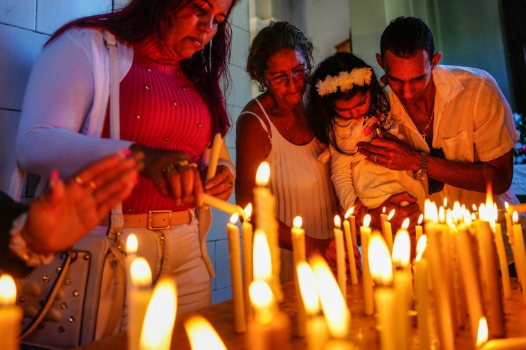 People light candles at El Cobre shrine in Cuba