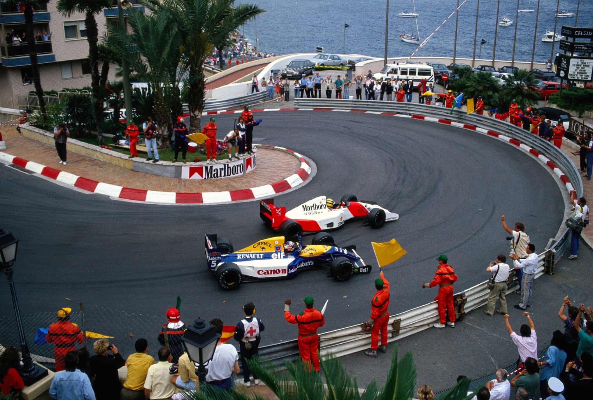 Marshals and fans salute race winner Ayrton Senna, McLaren MP4-7A Honda, and second positioned Nigel Mansell, Williams FW14B Renault, on the slowing down lap during the 1992 Monaco Grand Prix.