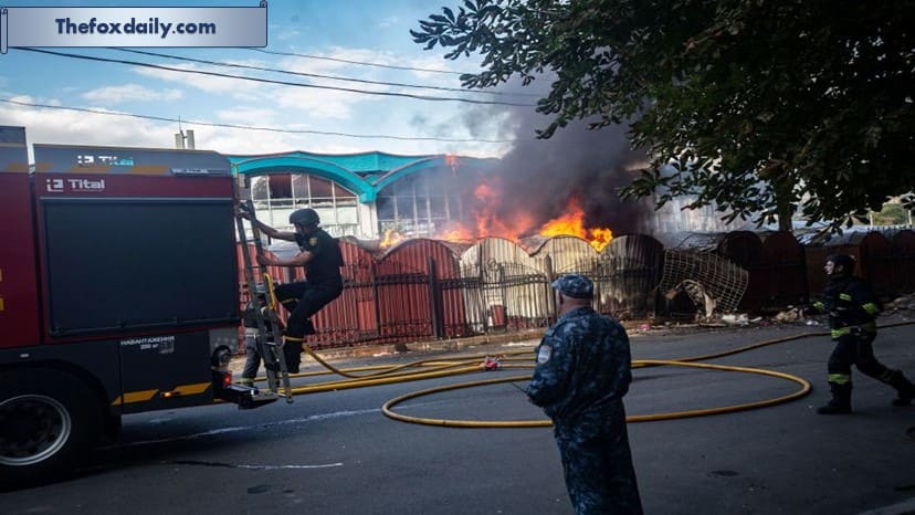 Emergency services workers extinguish a fire, caused by the explosion of a Russian drone, at the central market in Sumy, Ukraine, earlier in the day on Friday