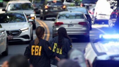 FBI members walk outside the home of the former White House national security adviser John Bolton in Bethesda, Maryland on August 22. FBI members walk outside the home of the former White House national security adviser John Bolton in Bethesda, Maryland on August 22.
