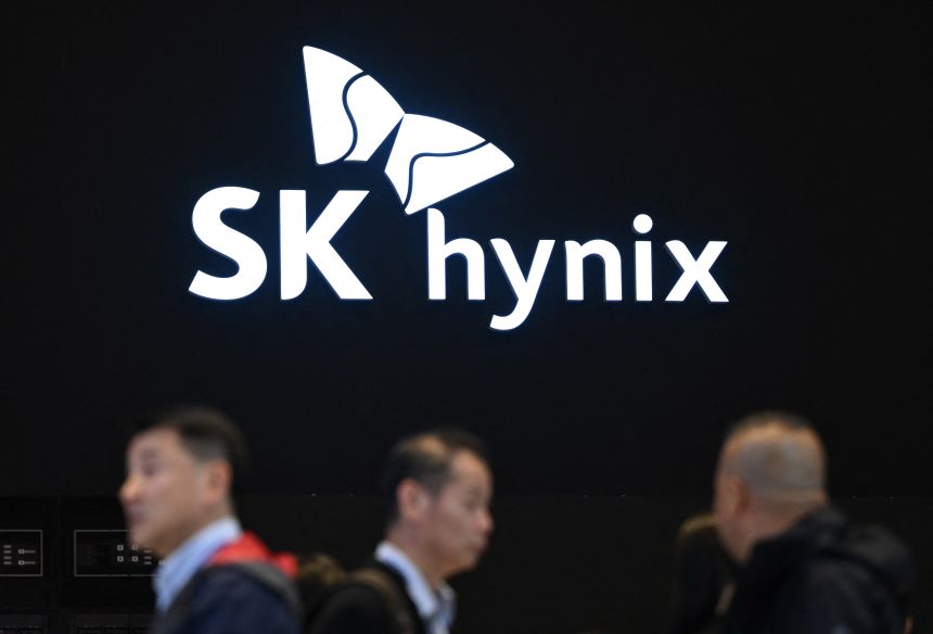 People walk past the logo of SK hynix during a semiconductor exhibition at the COEX convention and exhibition centre in Seoul on October 24, 2024
