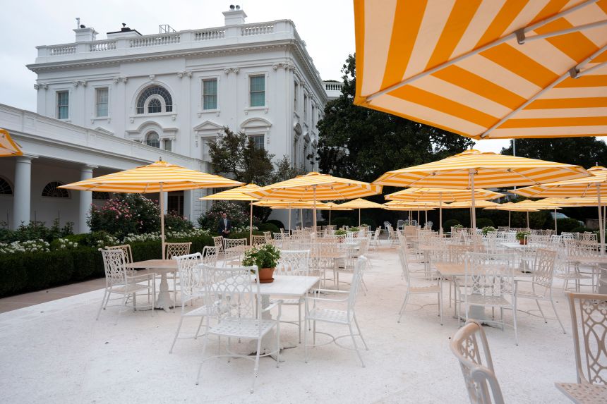 Yellow and white striped umbrellas are open in the recently renovated Rose Garden at the White House, in Washington, DC on August 19