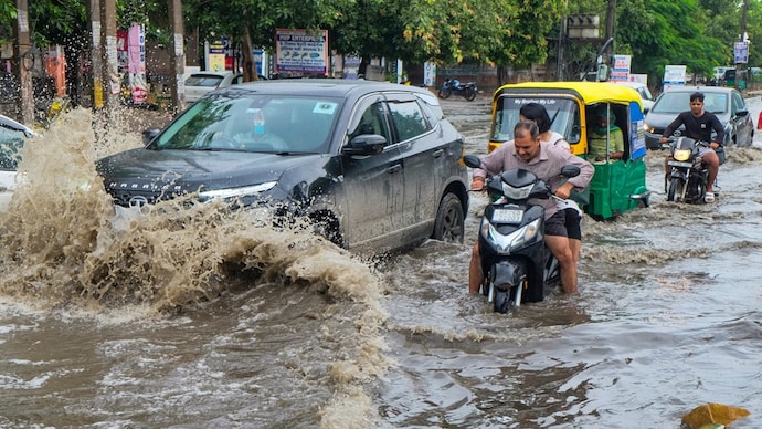 Commuters make their way through a waterlogged Gurugram street earlier this week