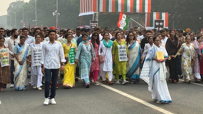 Mamata Banerjee walking with a copy of the Constitution in hand.