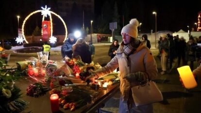 A woman leaves flowers outside the "Le Constellation" bar, after a fire and explosion during a New Year's Eve party where several people died. A woman leaves flowers outside the "Le Constellation" bar, after a fire and explosion during a New Year's Eve party where several people died.