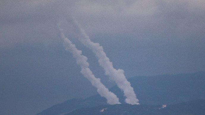 Smoke rises as projectiles are fired from Lebanon towards Israel.
