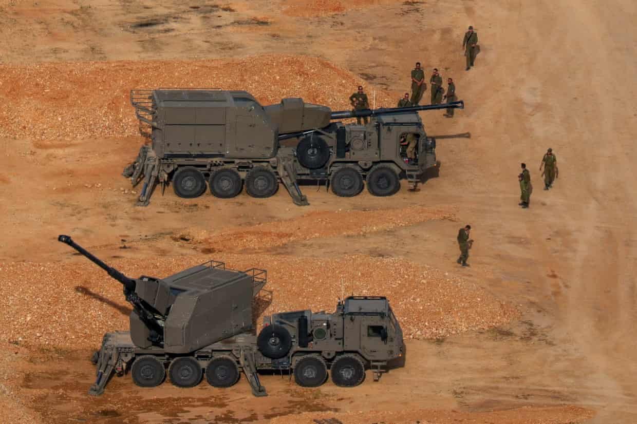 Israeli soldiers next to artillery vehicles near the Israel-Lebanon border, in northern Israel