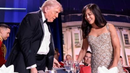 Donald Trump and Weijia Jiang taking their seats at a table in the room where the dinner was taking place