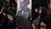 Women gather around a portrait of Iran's Supreme Leader, Ayatollah Mojtaba Khamenei, during a ceremony honoring the armed forces