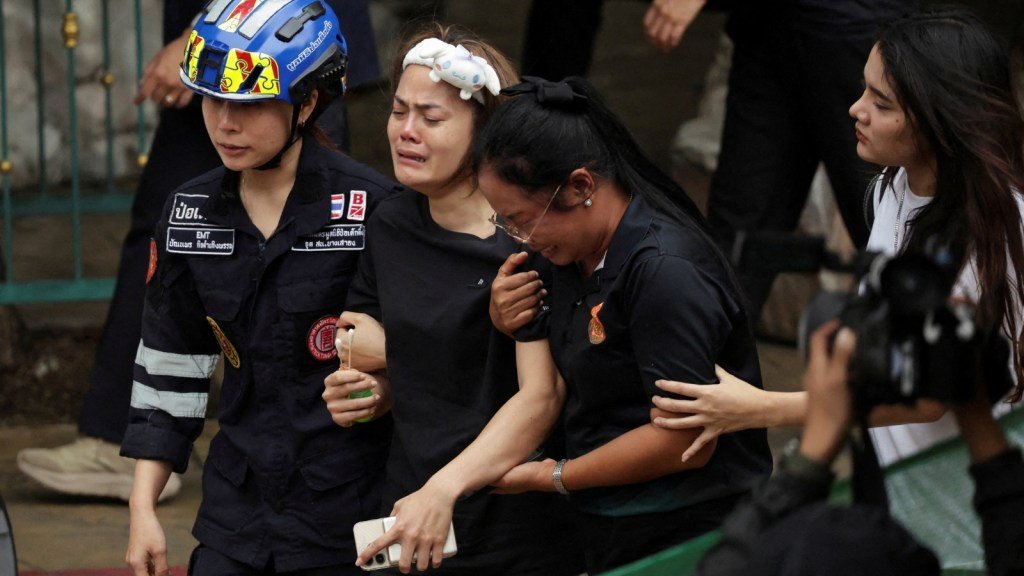 The wife of a teacher who was shot dead reacts at the Debsirin Nonthaburi School following the shooting incident, in Bang Kruai district in Nonthaburi province on the outskirts of Bangkok, August 7, 2026.