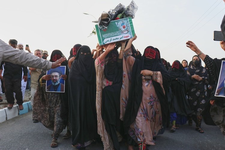 Women carry a coffin during a mass funeral for people killed when a US missile struck a home where a wedding was being held.