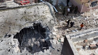 People inspect damage and debris at a building that Iranian media said was hit by a U.S. strike while a wedding celebration was taking place there, in Kuhestak, southern Iran.